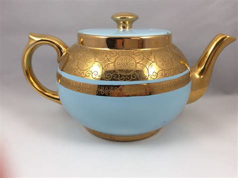 Includes a coffee pot, tea pot, creamer pitcher and sugar bowl in a black high glaze finish with gold gilt spout and handle, and gilt central band. . Gibson and sons teapot